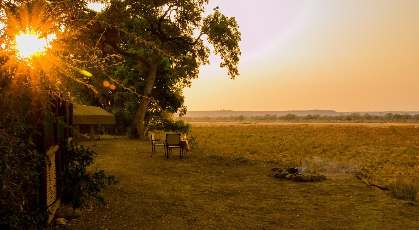 Het terras van Mahove Bush Camp kijkt uit over de zonnige Gonarezhou-overstroomingsvlakte in de schemering.