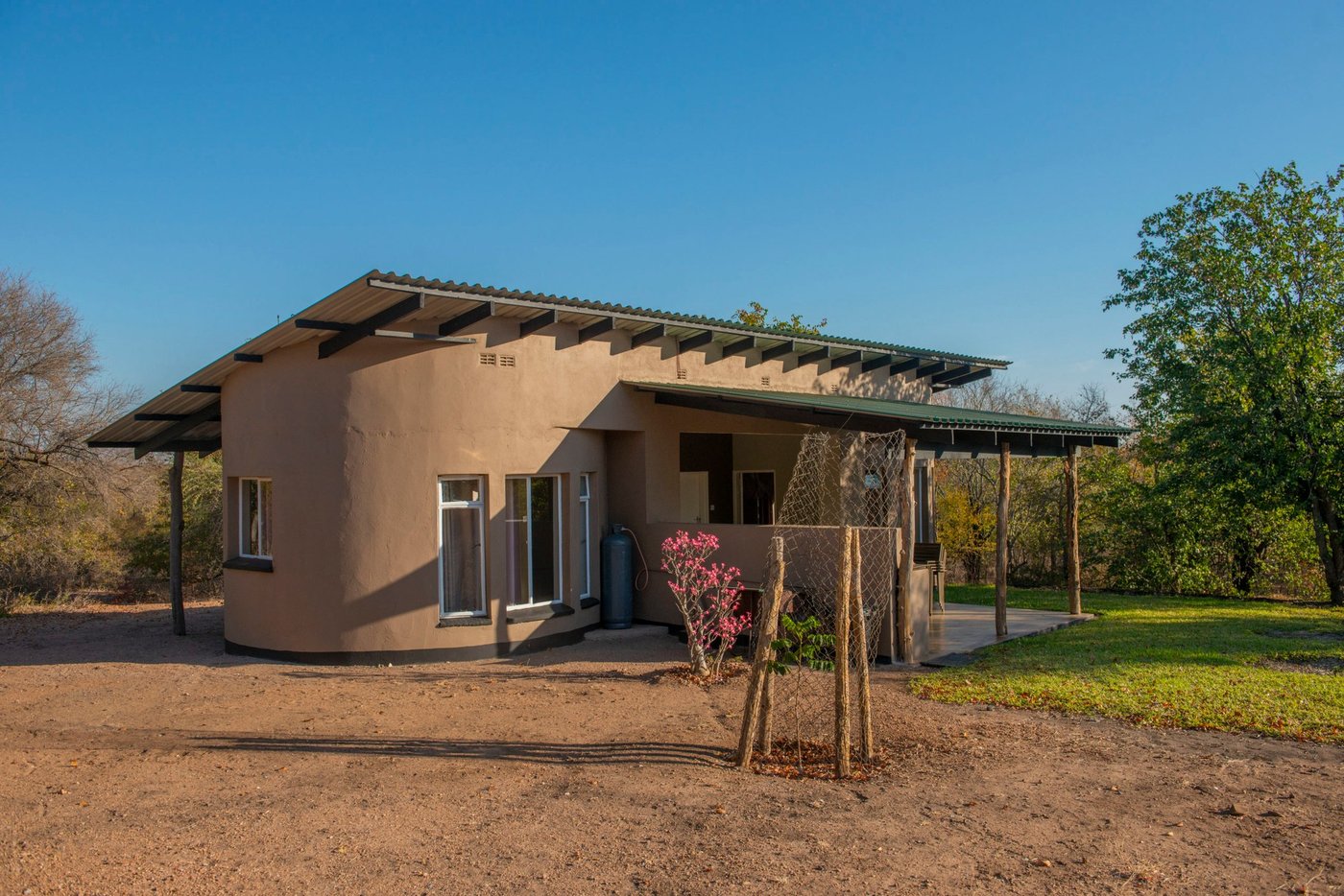 Een modern chalet met een overdekt carport staat op het terrein van Swimuwini Rest Camp.